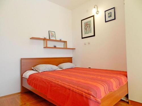 sypialnia z łóżkiem z pomarańczowym kocem w obiekcie Apartment Darko w mieście Tribunj