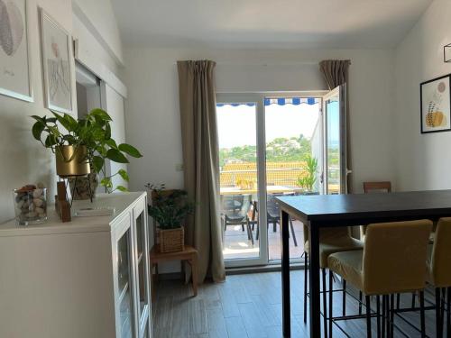 a dining room with a table and a balcony at Apartman I & R in Nečujam