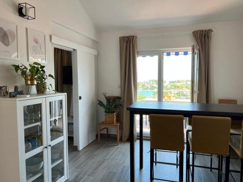 a dining room with a table and chairs and a window at Apartman I & R in Nečujam