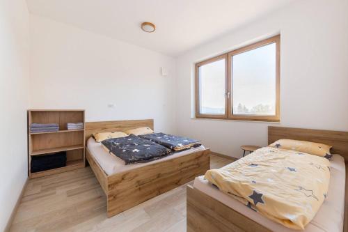 1 dormitorio con 2 camas y ventana en Duplex Holiday Apartment en Škofljica