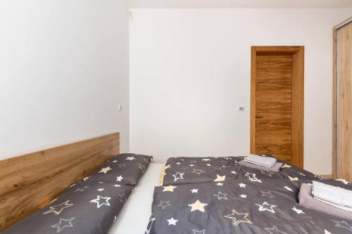 a bed with a black comforter with stars on it at Duplex Holiday Apartment in Škofljica