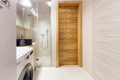 a bathroom with a shower and a sink and a door at Duplex Holiday Apartment in Škofljica