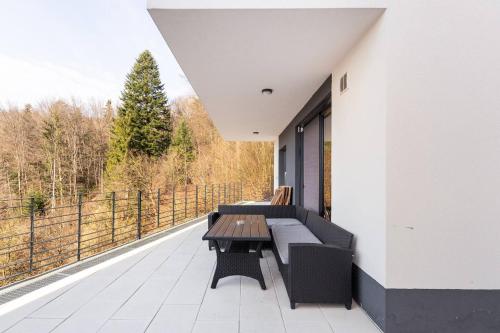 a balcony with a bench and a table on a building at Duplex Holiday Apartment in Škofljica
