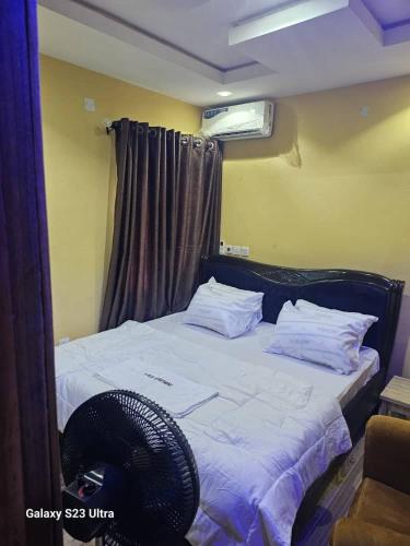 una camera con letto, ventilatore e finestra di A-Plus Apartment ad Asi