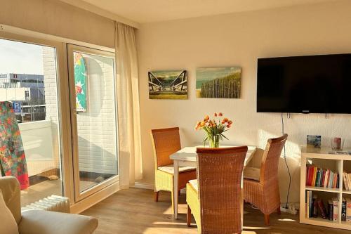 ein Wohnzimmer mit einem Esstisch und einem TV in der Unterkunft LUV & LEE Waterkant Ferienwohnung SPO in Sankt Peter-Ording