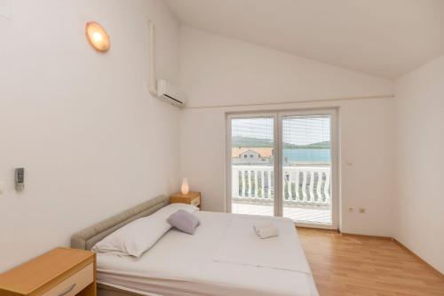 a bedroom with a bed and a large window at Apartments Rosanda in Pirovac