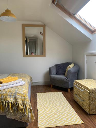 a room with a couch and a chair and a mirror at First floor Pad Carterton near Burford in Shilton