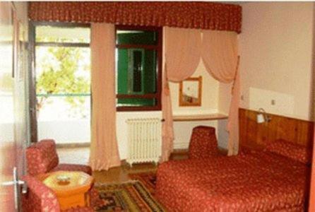 a bedroom with a bed and a couch and a window at Auberge des Cascades Imouzzer - Paradise Valley in Imouzzer des Ida Ou Tanane