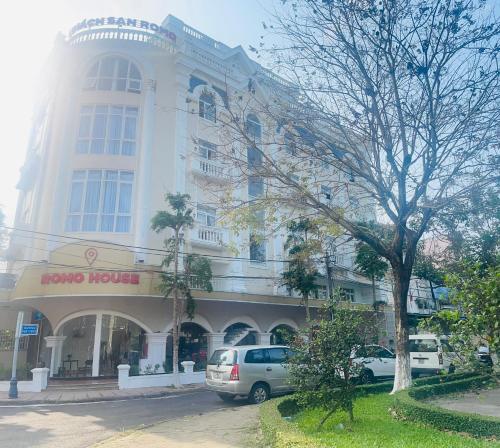 a large building with cars parked in front of it at KHÁCH SẠN ROMO in Quang Ngai