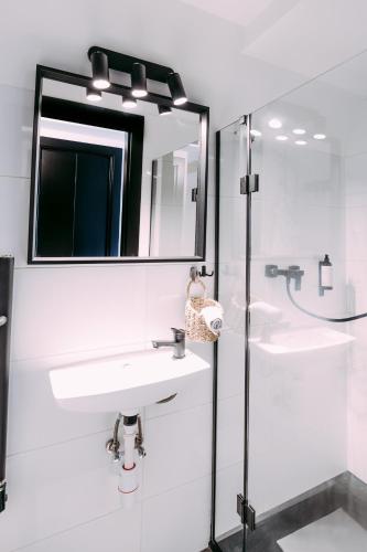 a bathroom with two sinks and a mirror at NOI Resort SPA - woda i las in Tęgoborze