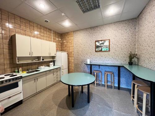 a kitchen with a table and a blue counter top at Hostelis R27 in Aizpute