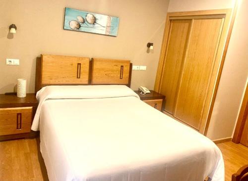 a bedroom with a white bed in a room at Hotel Spa Galatea in Burela de Cabo