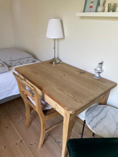 uma mesa de madeira com um candeeiro em cima de uma cama em Cutest annex - close to Heatherhill and sea :-) em Vejby