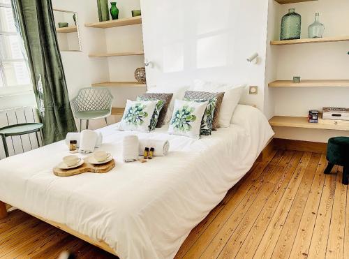 - un lit blanc avec des chapeaux et des serviettes dans l'établissement L emeraude - Trouville, à Trouville-sur-Mer