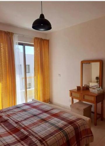 1 dormitorio con cama, tocador y espejo en Bright One Bedroom Apartment in Paphos area en Pafos