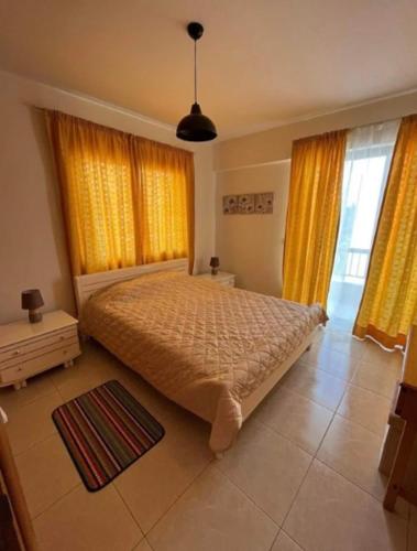 1 dormitorio con 1 cama y cortinas amarillas en Bright One Bedroom Apartment in Paphos area en Pafos