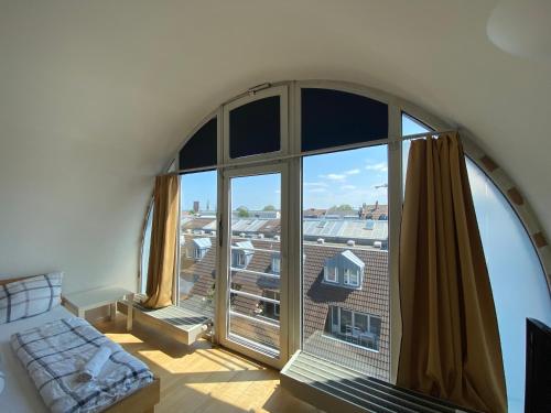 a living room with a large window and a couch at Simplex Apartments Am Ludwigsplatz in Karlsruhe