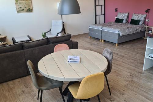 - un salon avec une table, des chaises et un canapé dans l'établissement Panta Rhei - Logement de 12e stad, à Berlikum