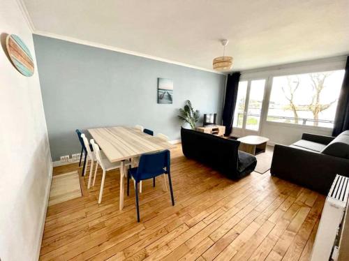un salon avec une table, des chaises et un canapé dans l'établissement Côté Sable, un balcon sur la mer - parking inclus, à Boulogne-sur-Mer