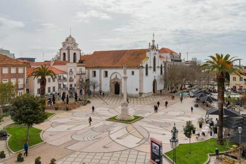 a group of people walking around a plaza in front of a church at Bocage Penthouse in Setúbal