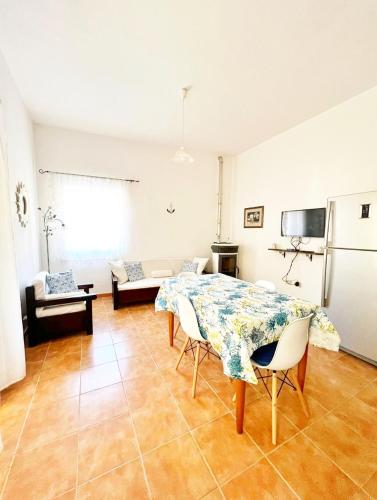 a living room with a table and chairs in it at La Pavoncella Holiday Home in San Vito