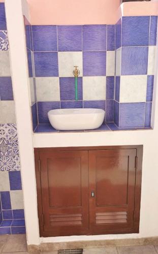 a bathroom with a sink and blue and white tiles at La Pavoncella Holiday Home in San Vito