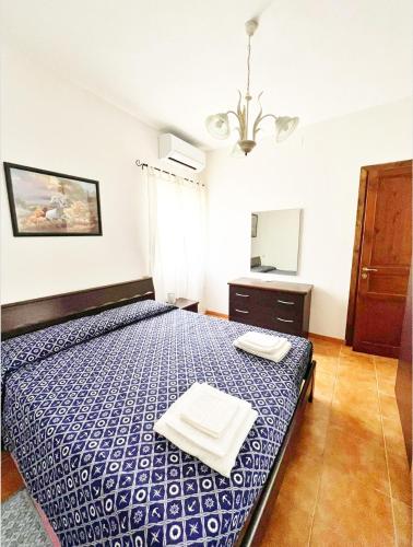 a bedroom with a bed with two towels on it at La Pavoncella Holiday Home in San Vito