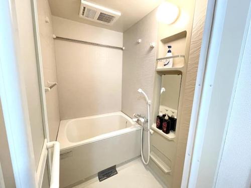 a white bathroom with a tub and a shower at S2 Shibuya House 850m from Shibuya Sta in Tokyo