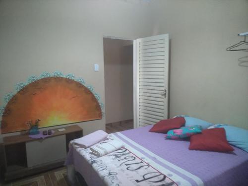 a bedroom with a bed with a rainbow on the wall at Pousada Refúgio da Chapada in Cavalcante