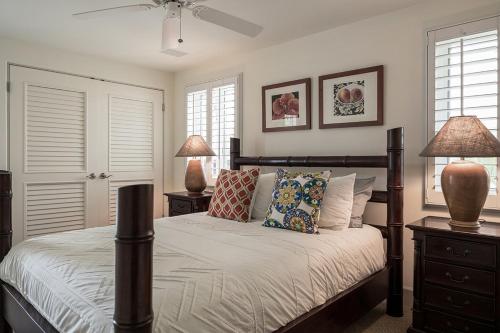 a bedroom with a bed with two night stands and two lamps at Kove Villa in Honolulu