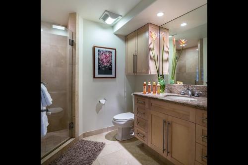 a bathroom with a shower and a toilet and a sink at Kove Villa in Honolulu