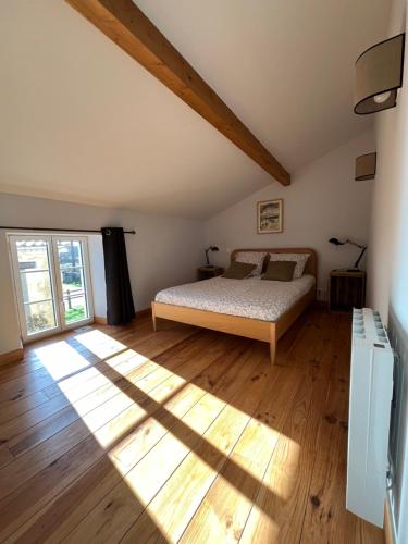 a bedroom with a bed and a wooden floor at Château La Fon du Berger in Saint-Sauveur