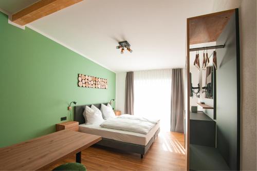 a bedroom with a bed and a table and a window at MK Appartements in Bad Abbach