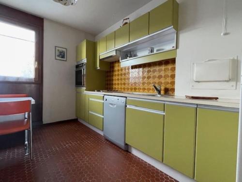 une cuisine avec des placards verts et jaunes et un évier dans l'établissement Nanterre Mont Valérien, à Nanterre