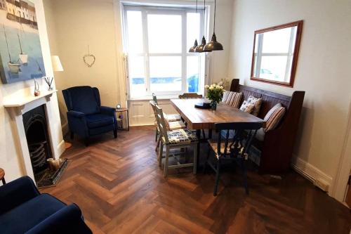a living room with a dining room table and chairs at 4 bedroom house opposite the sea in Kent