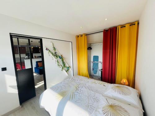- une chambre avec des rideaux colorés et un lit dans l'établissement La Brise Marine, à Calais