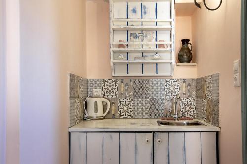 a kitchen with white cabinets and a sink at Ktima Karageorgou in Areopolis