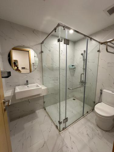 uma casa de banho com um chuveiro, um lavatório e um WC. em Avery Luxury Apartment TMS Quy Nhơn em Quy Nhon