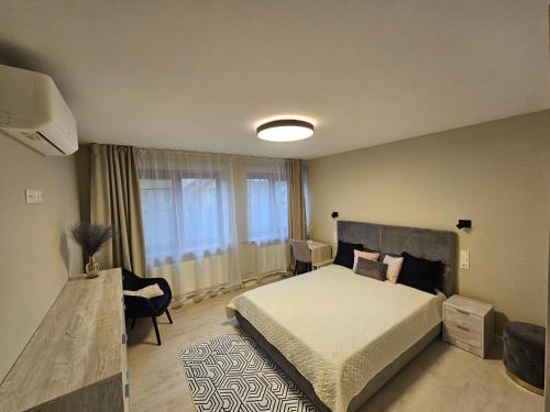 ein Schlafzimmer mit einem Bett und einem großen Fenster in der Unterkunft ANTRI Namai - Apartamentai Birštone in Birštonas