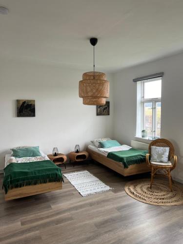 sypialnia z 2 łóżkami, krzesłem i oknem w obiekcie Atelierhaus Hilmsen 