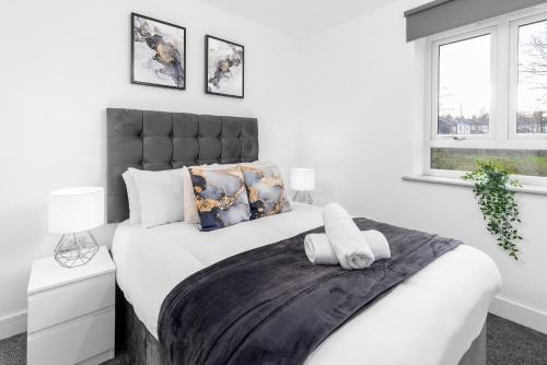 ein weißes Schlafzimmer mit einem großen Bett und zwei Fenstern in der Unterkunft Smetwhick Deluxe 2 Bed Apartment - Balcony - Secure Parking - 4MC in Birmingham