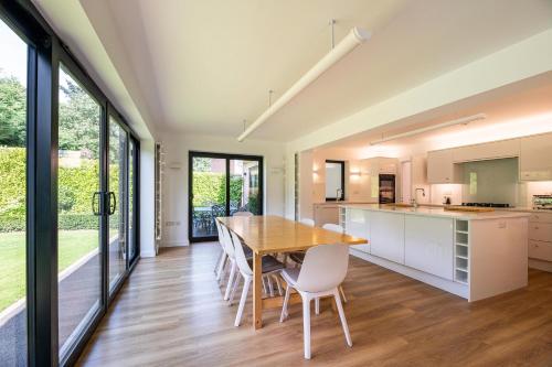 a kitchen and dining room with a wooden table and chairs at Lyndhurst House in Canterbury