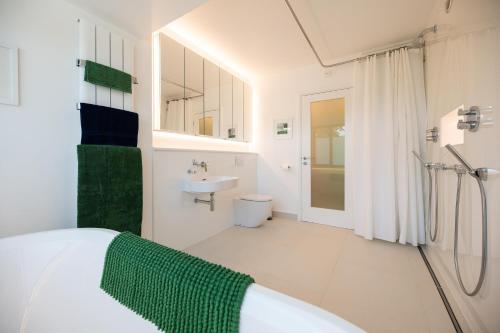 a white bathroom with a bed and a sink at Lyndhurst House in Canterbury