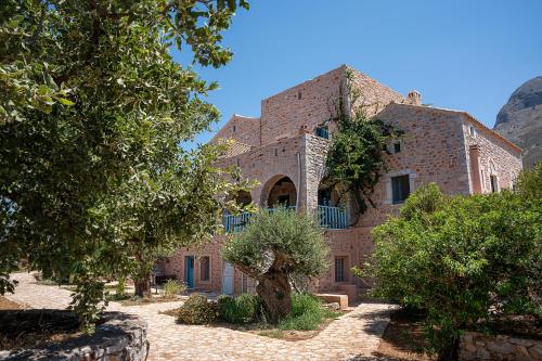 a large brick building with trees in front of it at Ktima Karageorgou in Areopolis