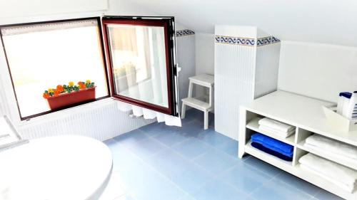 een kleine badkamer met een koelkast en een raam bij alaia apartamento in Zarautz