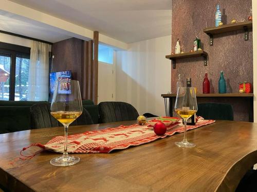 dois copos de vinho sentados numa mesa de madeira em Lonvilla’s Brezovicë em Štrpce