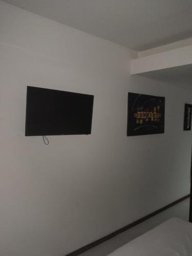 a flat screen tv hanging on a white wall at Sonia Flats Pipa's Bay - Flat 211 in Pipa