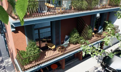un edificio de apartamentos con balcón con sillas y plantas en Villa Noem, en Tirana