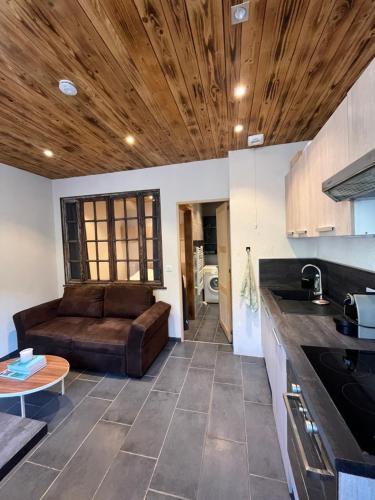 - une cuisine avec un canapé au milieu d'une pièce dans l'établissement Appartement à Sevrier, à Sévrier