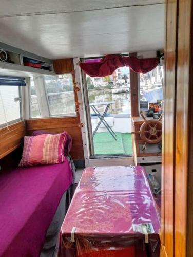 une petite pièce avec un lit et une fenêtre dans l'établissement Studio bateau Narbonne, à Narbonne